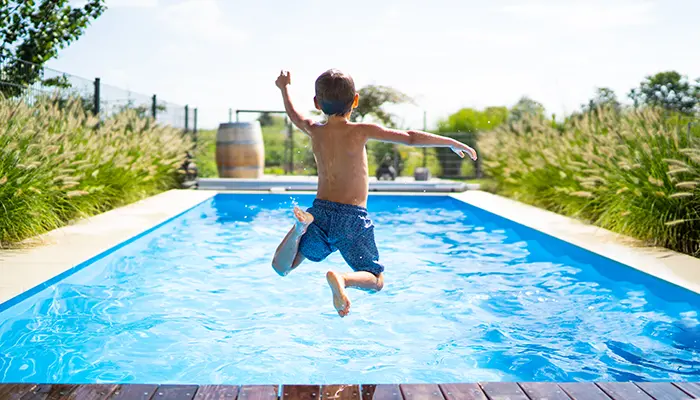 Barn som hoppar i en pool.