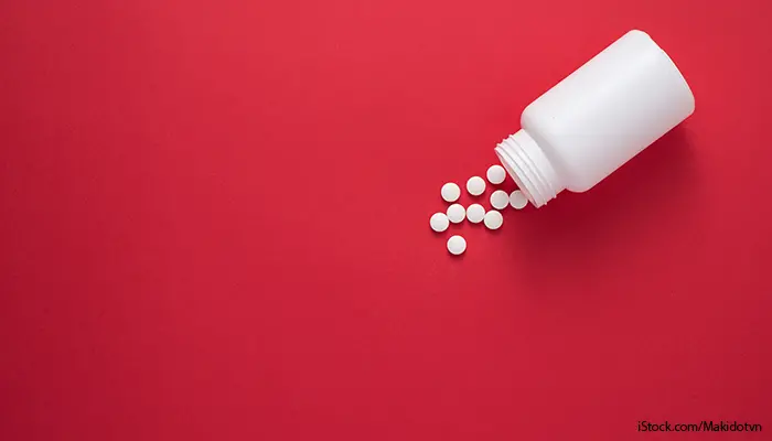 Vita tabletter på röd bakgrund.